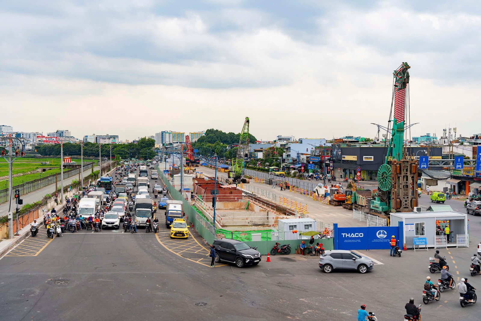Công trường thi công metro số 2 với cần cẩu, hố đào và hàng rào chắn dọc trục đường lớn