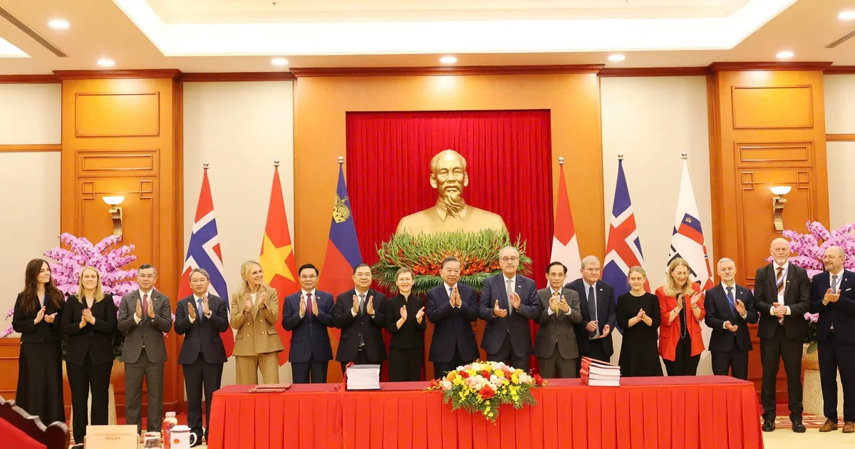 Lễ ký Hiệp định thương mại tự do Việt Nam–EFTA tại Hà Nội ngày 18/10/2026: đại diện các bên đứng vỗ tay phía sau bàn ký, trước quốc kỳ các nước